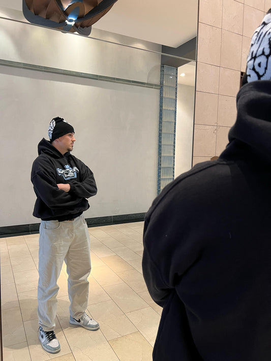 Model traägt den Streetwear Logo Hoodie und einen Beanie